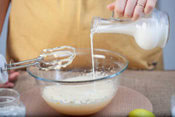 Healthy And Super Easy Homemade Ice Cream Ideas & Recipes image 3 person pouring milk into bowl of cream with hamd mixer ready to combine Frosted Fusions