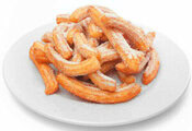 Homemade Cinnamon & Churros Ice Cream Spice and Crispy Comfort update Sep25 image 1 pile of churros on white plate white background frosted fusions