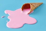How-To-Stop-Homemade-Ice-Cream-From-Melting-Too-Fast-image-1-ice-cream-waffle-cone-with-pink-ice-cream-puddle-of-melted-ice-cream-blue-background-Frosted-Fusions