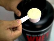 protein-shake-fusions-creating-protein-rich-low-fat-homemade-ice-cream-image-1-scoop-of-protein-powder-with-whey-protein-bottle-in-background-frosted-fusions