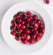 cherry-bakewell-bliss-a-delectably-classic-cherry-bakewell-homemade-ice-cream-image-2-jpeg-white-plate-filled-with-bright-red-cherries-white-background-frosted-fusions