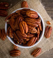 easy-homemade-brown-butter-pecan-ice-cream-image-2-bowl-filled-with-pecans-on-a-wooden-surface-frosted-fusions