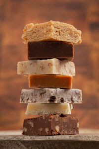 Classic-Fudge-Meets-Chocolate-Fudge-Ice-Cream-–-Trendy-Nostalgia-image-6 stack of different styles of fudge Frosted-Fusions Classic-Fudge-Meets-Chocolate-Fudge-Ice-Cream-–-Trendy-Nostalgia-image-6 stack of different styles of fudge Frosted-Fusions