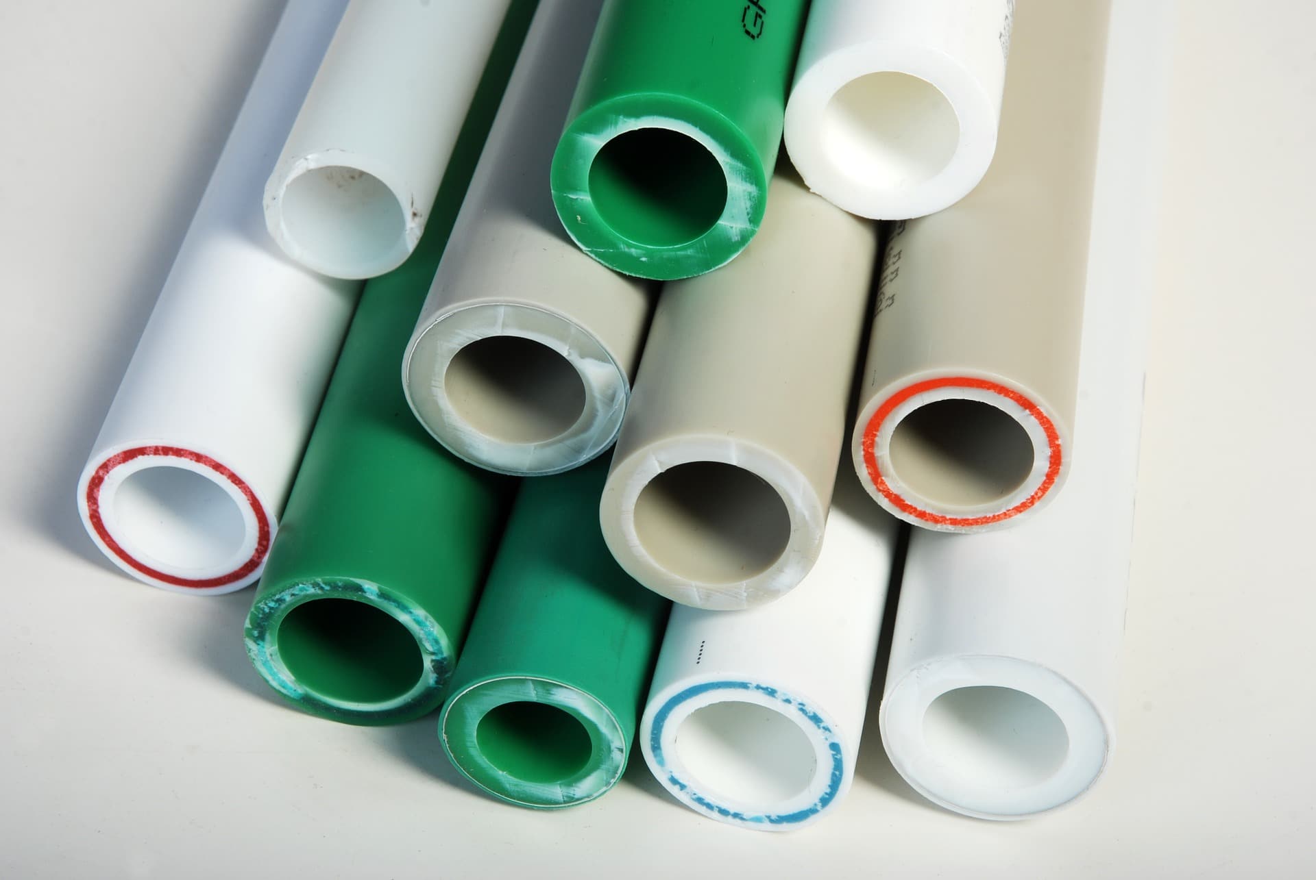 A variety of plastic pipe in green, white and beige colors. Plastic pipe materials have evolved with the advancements and demands of the water industry.