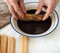 indulge-your-senses-with-a-decadent-tiramisu-ice-cream-recipe-image-2-handful-of-lady-fingers-with-one-being-soaked-in-a-coffee-liquid-frosted-fusions