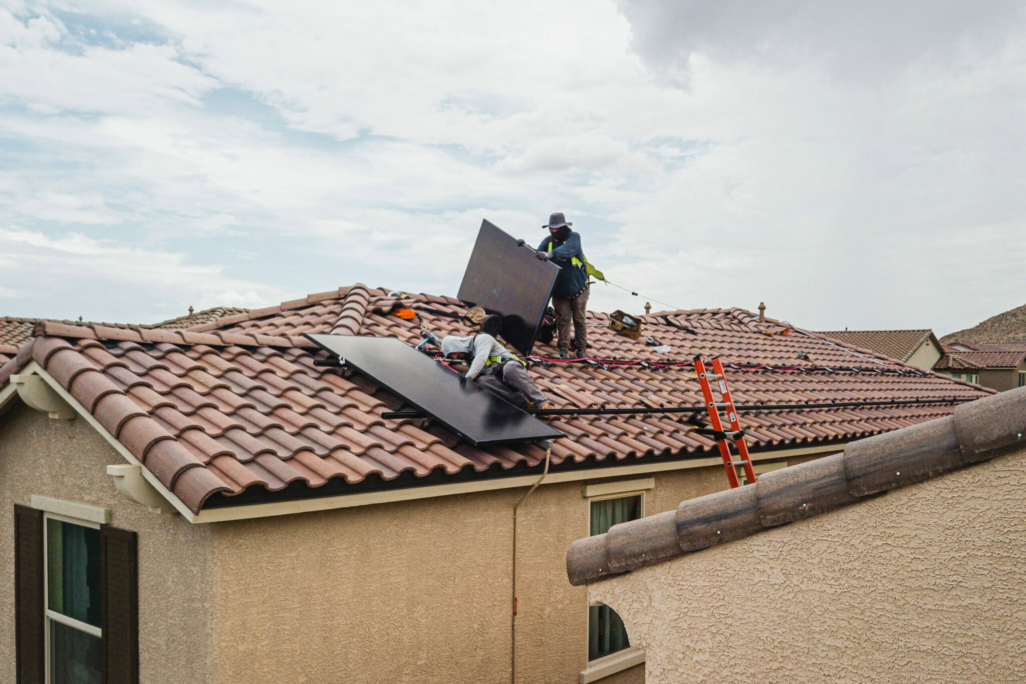 Solar installers installing panels on a roof.