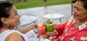 A Delicious And Nutrient-Packed Berry Blast Smoothie image 6 two ladies chinking their red and green smoothies with smiles frosted fusions