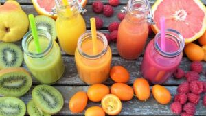 Différents jus de fruits frais avec des fruits comme le kiwi et l'orange