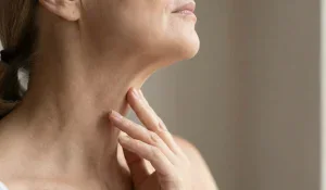 mature woman touching neck natural light