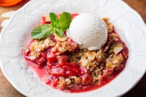 Homemade-Rhubarb-Ice-Cream-A-Truly-Tantalisingly-Tangy-Treat-image-5-dish-with-rhubarb-crubmle-served-with-scoop-of-ice-cream-with-fresh-mint-leaves-frosted-fusions