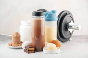 Protein-Shake-Fusions-Creating-Protein-Rich-Low-Fat-Homemade-Ice-Cream-update-Feb25-image-1-glasses-of-protein-shakes-with-dumbbell-in-the-background-Frosted-Fusions