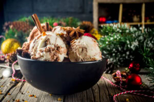 How-To-Pair-Ice-Cream-With-Classic-Christmas-Desserts-image-5-black-bowl-filled-with-ice-cream-with-festive-decorations-in-the-background-frosted-fusions