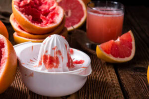 Learn-How-To-Make-The-Perfect-Blood-Orange-Sorbet-image-1-blood-oranges-being-juiced-with-manual-juicer-Frosted-Fusions.