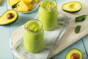 Quick-Easy-And-Deliciously-Healthy-Breakfast-Smoothie-Recipes-image-5-avocado-spinach-and-pineapple-smoothie-with-fresh-avocado-spinach-leaves-and-fresh-pineapple-to-the-side-Frosted-Fusions