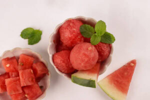 Watermelon-Sorbet-Granita-–-A-Refreshing-Taste-Of-Spring-image-3-top-view-water-melon-sorbet-in-dish-with-leaves-and-fresh-watermelon-Frosted-Fusions