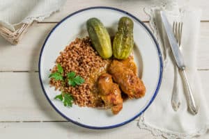 A recipe for bitki wolowe, a plate with chicken, beans, and pickles.