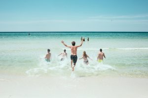 famille qui plonge dans la mer depuis une plage