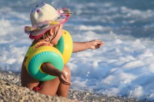 Petite fille avec des brassards au bord de la mer
