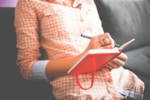 Jeune femme en train d'écrire dans son journal intime.