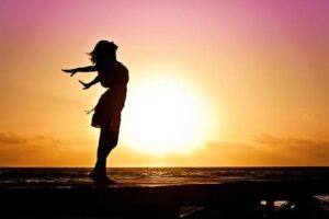 Silhouette de femme devant soleil couchant