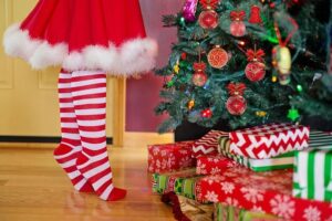 Tas de cadeaux emballés devant un sapin de Noël décoré