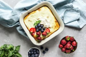 A refreshing dessert featuring fresh berries, a hint of mint, and a dollop of homemade whipped cream.