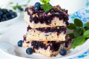 A stack of blueberry bars, a Polish dessert made with a blueberry cake recipe, on a plate.
