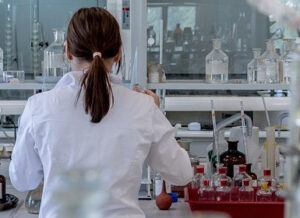 About us image 4 jpeg woman in white lab coating with glass bottles and experimental equipment surrounding her frosted fusions