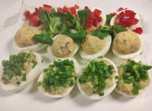 Polish deviled eggs are arranged on a white plate.