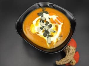 zupa dyniowa in a black bowl.