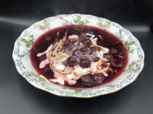 A bowl of Polish soup with cherries.