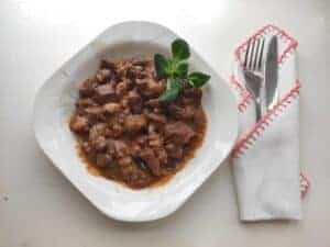 Authentic Polish Goulash Recipe served on a white plate with a fork.
