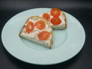 A plate with a slice of bread and tomatoes, representing Polish cuisine.