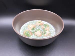 A bowl of soup with Polish meatballs in dill sauce.