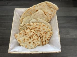 Polish flat bread in a white basket on a table.