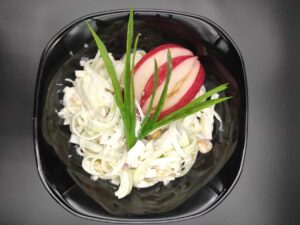 Salatka z pora in a black bowl.