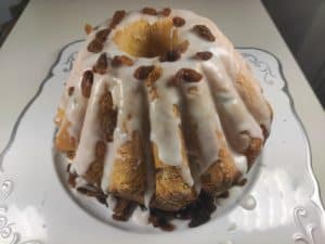 Babka drozdzowa topped with glaze and raisins.