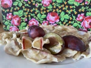 A plate of pasta with plum pierogi on it.