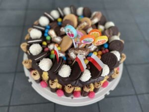 A decorated Polish chocolate cake topped with an assortment of candies and cookies.