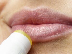 Femme qui s'applique un baume sur les lèvres