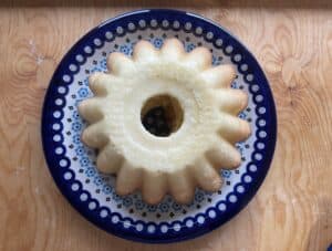 A gluten-free babka sits elegantly on a decorative blue and white plate, resting on a wooden surface.
