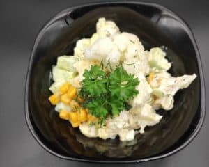 sałatka z kalafiora polish cauliflower salad in a black bowl.