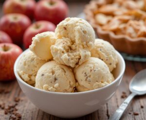 Spiced-Apple-Homemade-Ice-Cream-A-Twist-on-a-Classic-Pie-Favourite-image-8-bowl-of-Applie-Pie-ice-cream-with-fresh-Apples-and-Apple-pie-in-background-Frosted-Fusions