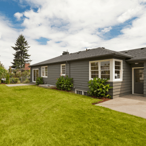 A beautiful rambler-style home featuring a single-level open floor plan, a spacious front yard, and a low-pitched roof, ideal for comfortable and accessible living