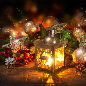 A festive lantern adorned with a deer silhouette glows among Christmas ornaments, including stars, pine cones, and baubles on a wooden surface, creating a charming Polish Christmas Corner.
