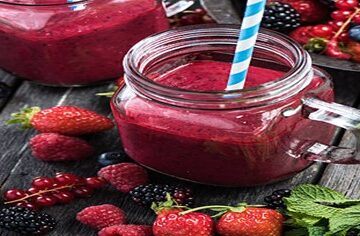 A-Delicious-And-Nutrient-Packed-Berry-Blast-Smoothie-featured-image-200x600w-reddish-pink-smoothies-glass-jars-several-types-of-berries-scattered-fresh-green-leaves-frosted-fusions