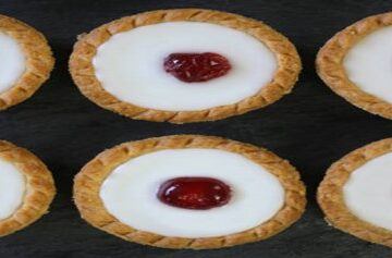 Cherry-Bakewell-Bliss-A-Delectably-Classic-Cherry-Bakewell-Homemade-Ice-Cream-featured-image-201x615w-jpeg-6-cherry-bakewells-lined-up-dark-background-frosted-fusions