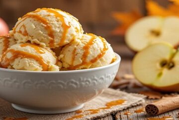 Why-Dont-We-See-Apple-Ice-Cream-Featured-Bowl-of-apple-ice-cream-scoops-with-caramel-drizzle-with-fresh-apples-cinnamon-sticks-and-autumn-leaves-Frosted-Fusions