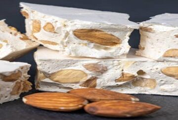 Homemade-Nougat-Ice-Cream-–-A-Classic-British-Treat-Reimagined-featured-image-207x620w-stack-of-nougat-with-almonds-nuts-wooden-background-Frosted-Fusions