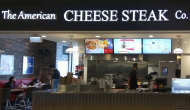 Front of the American Cheese Steak Co quick service restraurant with digital menu board mounted above the counter
